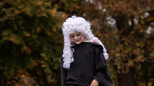 A child in a Georgian wig with face painting for Halloween